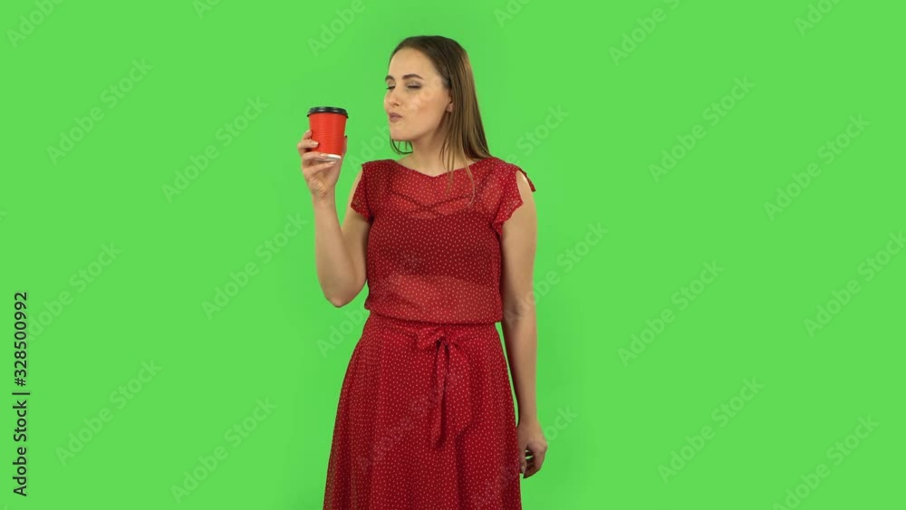 Tender girl in red dress is enjoying coffee. Green screen Tender girl in red dress is enjoying coffee. Green screen