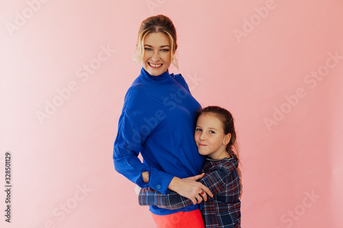 Beautiful woman 40 years with daughter on pink background