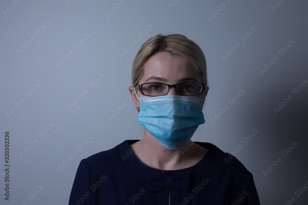 an attractive young woman wears a paper face mask to protect herself from the H1N1 Virus, isolated on white, with room for your text an attractive young woman wears a paper face mask to protect herself from the H1N1 Virus, isolated on white, with room for your text