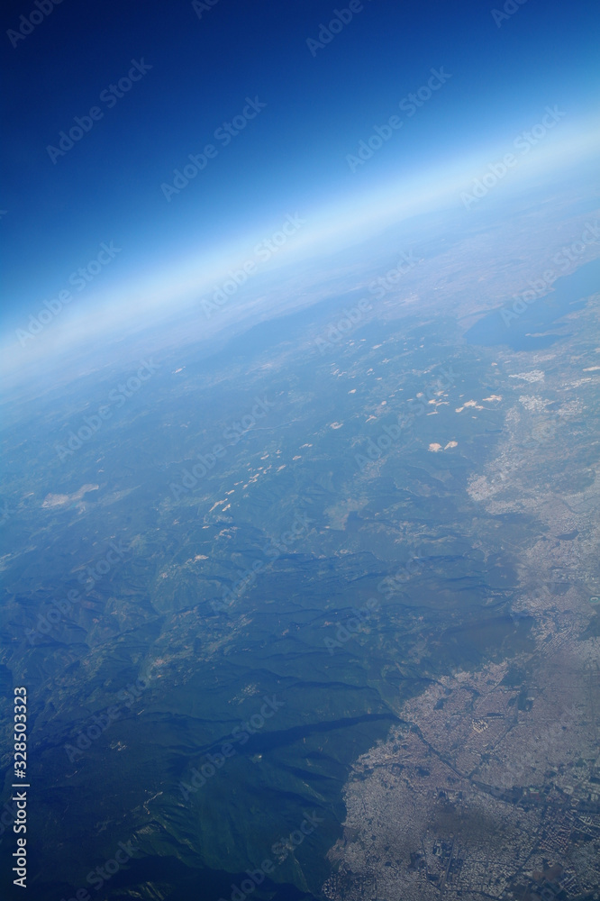 View from the plane window to the clouds and the earth