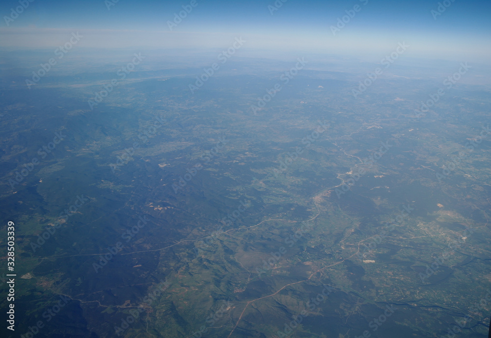 View from the plane window to the clouds and the earth