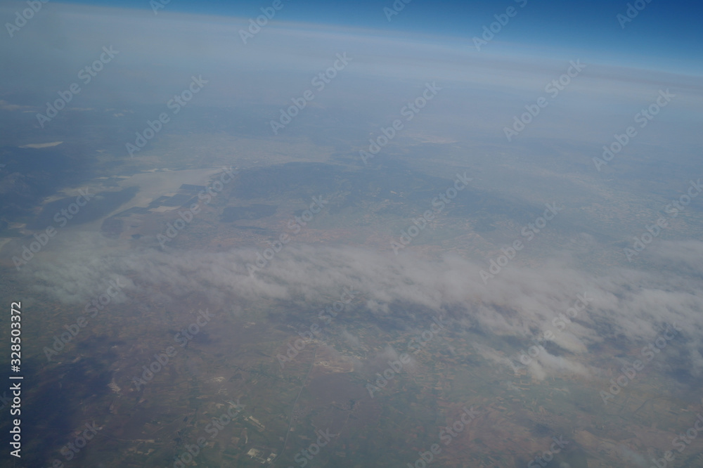 View from the plane window to the clouds and the earth