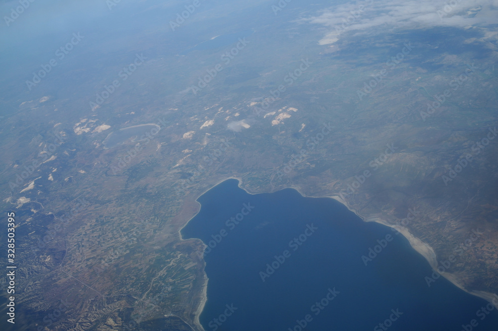 View from the plane window to the clouds and the earth
