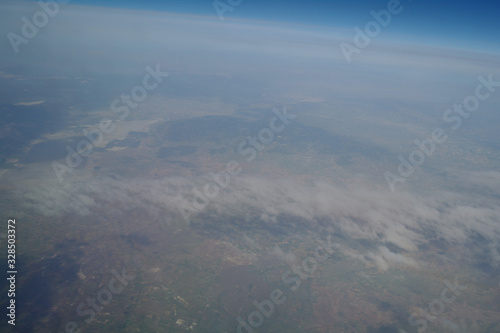 Obraz na płótnie View from the plane window to the clouds and the earth w salonie