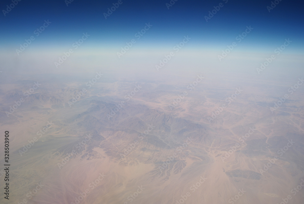 View from the plane window to the clouds and the earth