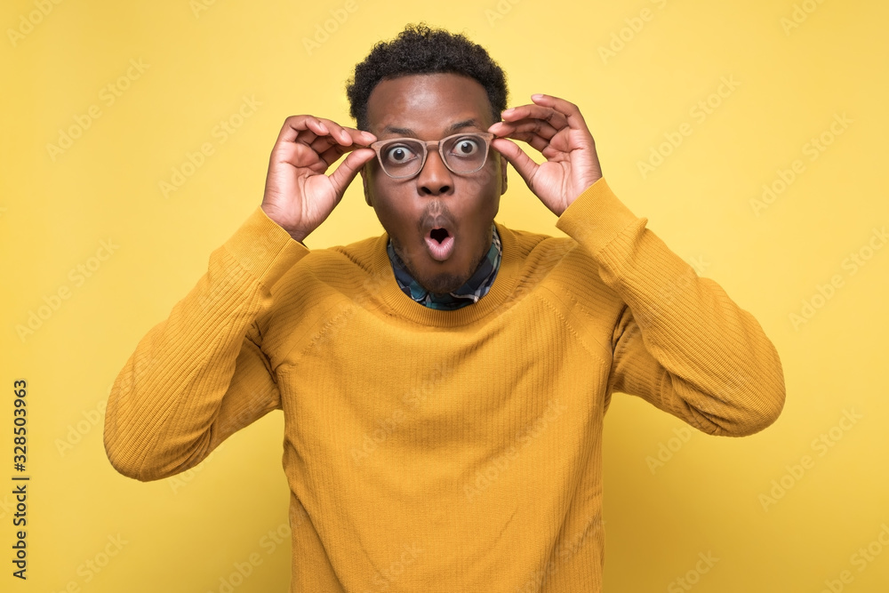 man looks into camera, rounds lips with surprisment, stares through spectacles man looks into camera, rounds lips with surprisment, stares through spectacles