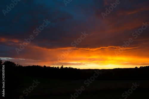 Spectacular fiery orange sunset over rolling hills