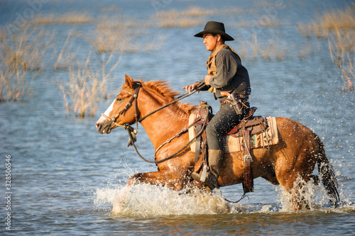 A man in a cowboy outfit with his horse