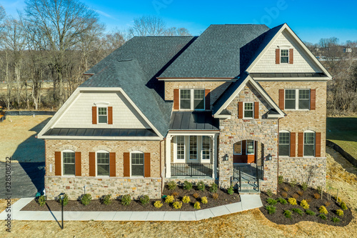 Photography Aerial view of luxury single family mansion home covered w/ shingle, brick, ston
