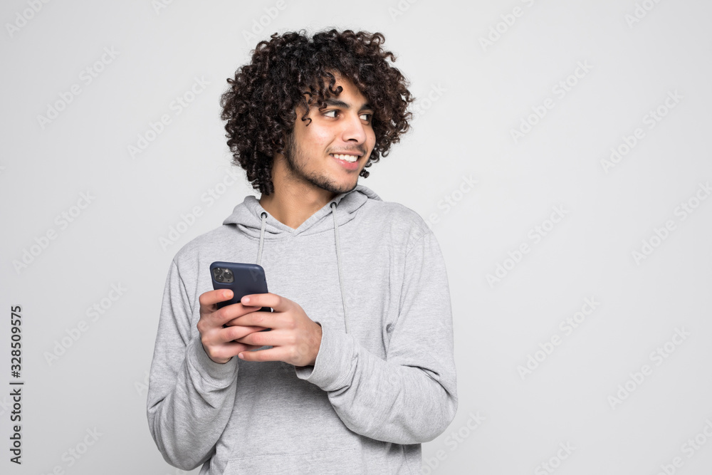Portrait of handsome curly man holding phone isolated on white background Portrait of handsome curly man holding phone isolated on white background