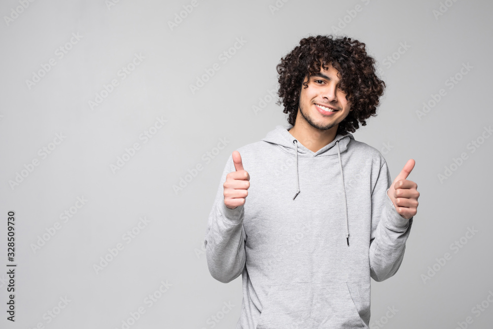 Smiling curly man lshowing thumb up isolated on a white background Smiling curly man lshowing thumb up isolated on a white background