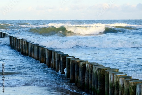 Waves crashing on the breakwater on a sunny day. Baltic Sea coast  Dziwnowek  Poland