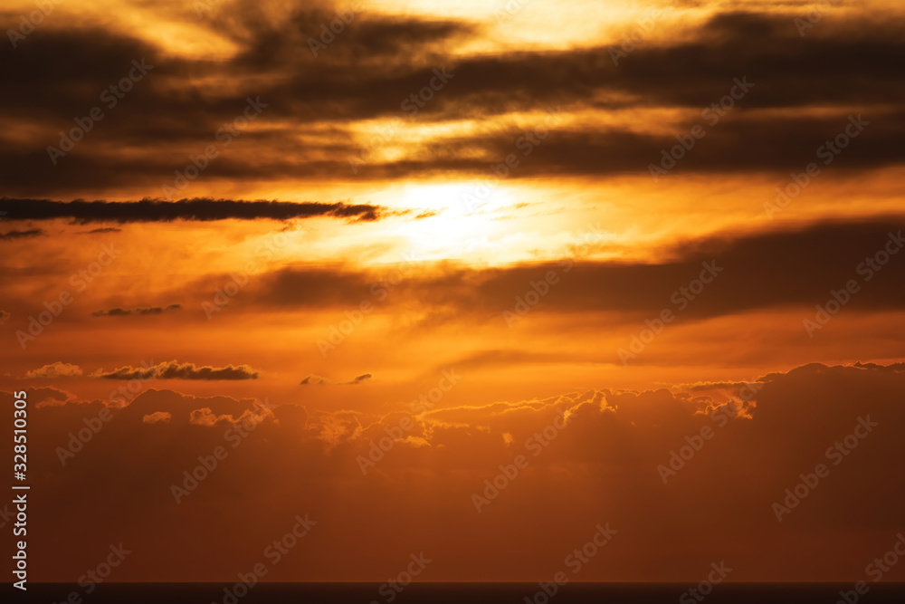 Aerial view of clouds over sea horizon lit by sunset sun
