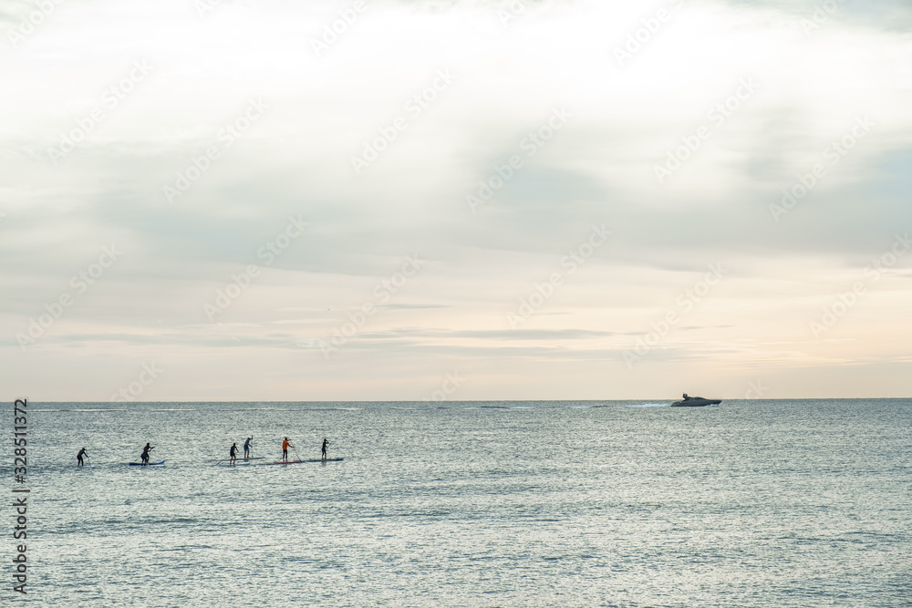 Group of people doing paddle surf in the Mediterranean sea. Barcelona, Spain.