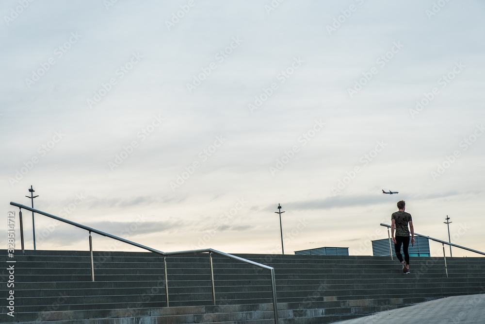 Hombre subiendo escaleras al amanecer con cielo de fondo. Hombre subiendo escaleras al amanecer con cielo de fondo.