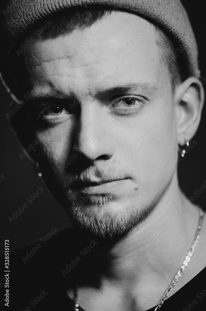Obraz premium Czarno-białe zdjęcie monochromatyczne. Portret puncker brodaty mężczyzna w kapeluszu. Koncepcja książki.