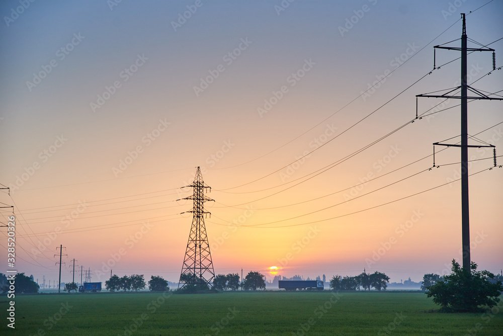 Power line in the field, morning dawn