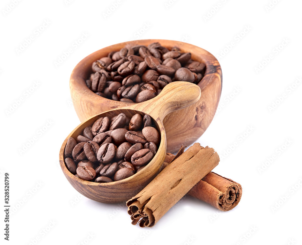 Fototapeta premium Coffee beans in a wooden spoon with cinnamon on white background.
