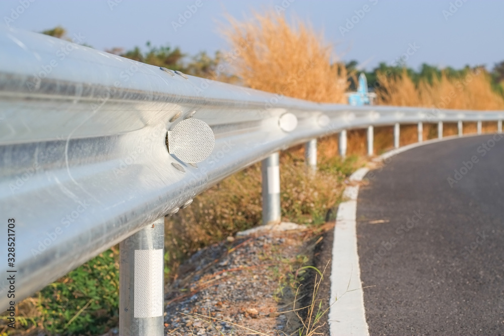 White reflective sign warn curve at night on the steel guard rail on the road in day time. White reflective sign warn curve at night on the steel guard rail on the road in day time.