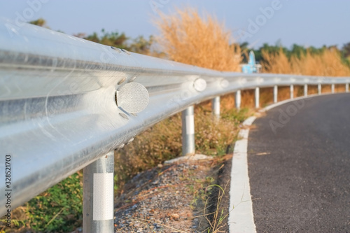 White reflective sign warn curve at night on the steel guard rail on the road in day time.