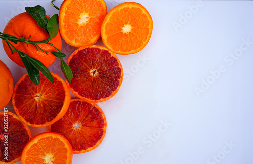 Platter of orange and mandarosa red clementines cut in half on a white platter