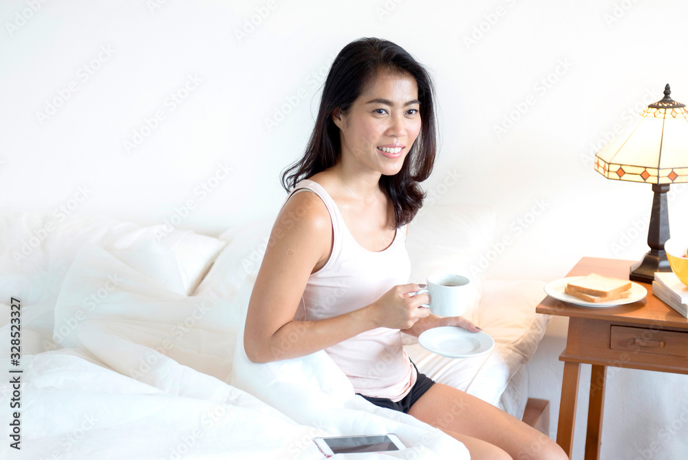 Asian healthy woman having breakfast in bedroom.healthy lifestyle concept Asian healthy woman having breakfast in bedroom.healthy lifestyle concept