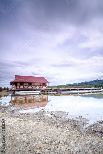 Beautiful view of frozen Maligne Lake with boat house, red roof in Jasper National Park