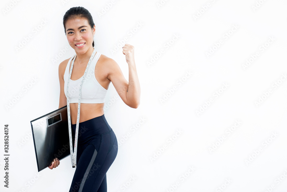 a beautiful asian sporty woman wear black and white outfit standing and posing with digital weight scale on white background.portrait of fitness healthy asian lady with healthy life style a beautiful asian sporty woman wear black and white outfit standing and posing with digital weight scale on white background.portrait of fitness healthy asian lady with healthy life style