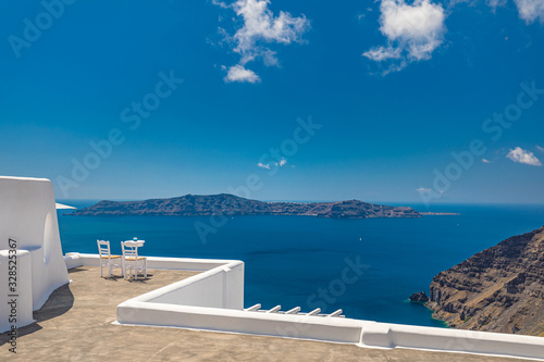 Two chairs on the terrace with sea views. Santorini island, Greece. Travel and vacation background. Best in travel landscape for romantic couple or honeymoon destination. Fantastic location and view