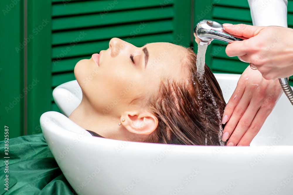 Naklejka premium Close up washing hair of woman.