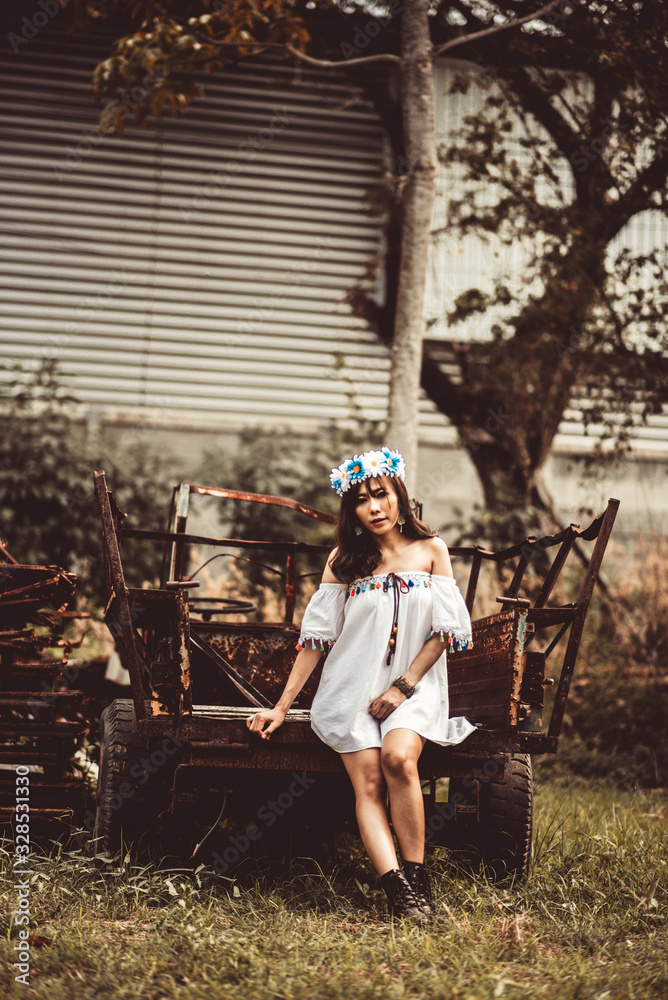 Young Woman Sitting On Abandoned Vehicle At Field