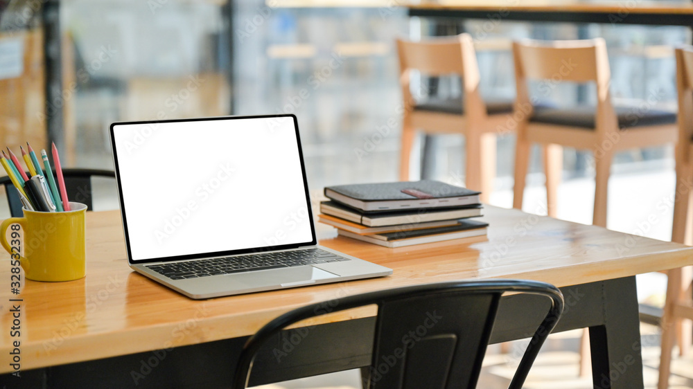 Cropped shot of Laptop with notebooks and stationary on a wooden desk in a modern office. Cropped shot of Laptop with notebooks and stationary on a wooden desk in a modern office.