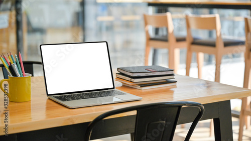 Cropped shot of Laptop with notebooks and stationary on a wooden desk in a modern office.