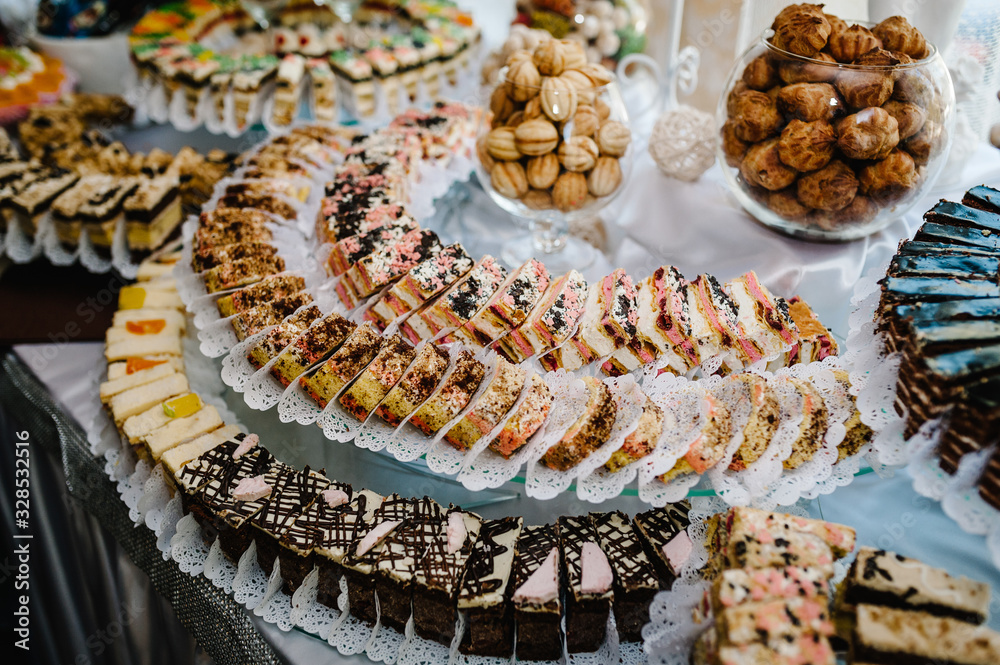 Sweet table. A plates of cakes and muffins with cream with berries. Table with sweets, candy, buffet. Dessert table for a party goodies. Close up. party reception, decorated in restaurant. candy bar