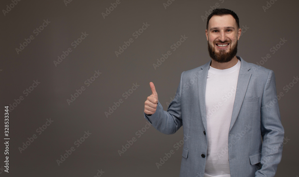 Happy businessman thumbs up sign on grey background Happy businessman thumbs up sign on grey background