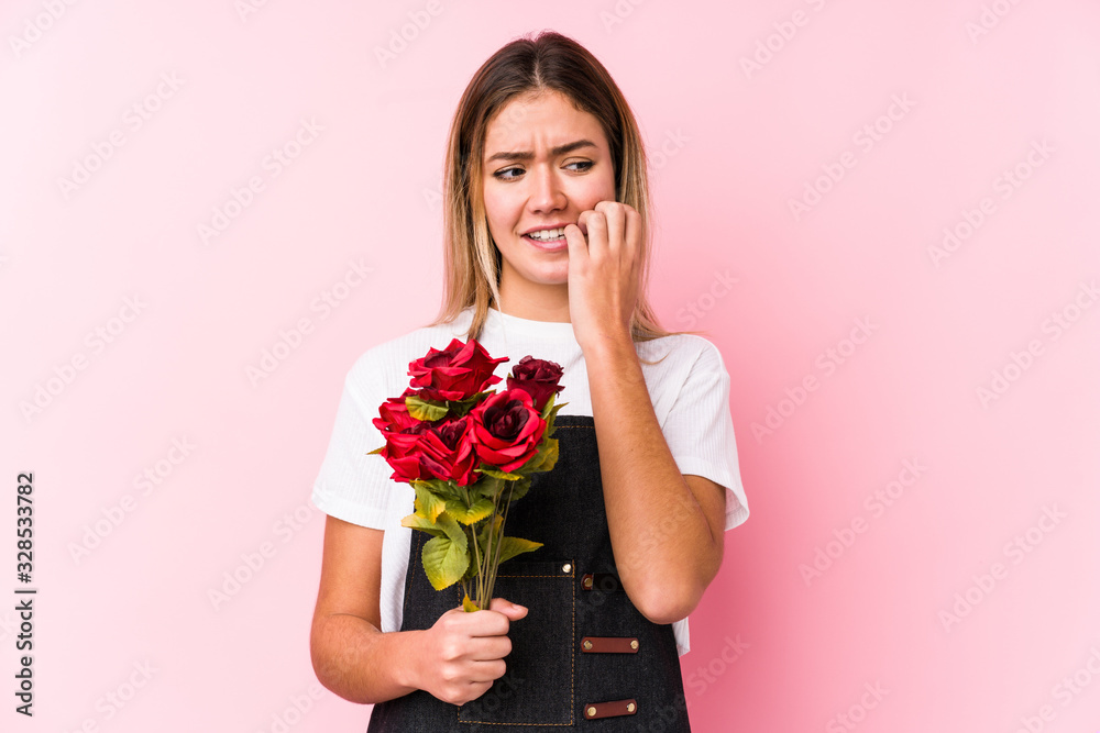 Young caucasian woman holding a roses isolated biting fingernails, nervous and very anxious. Young caucasian woman holding a roses isolated biting fingernails, nervous and very anxious.
