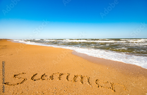Inscription on sand summer near stormy sea wave