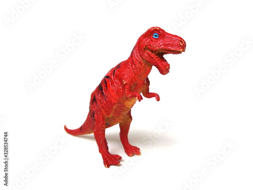 Close up of tyrannosaurus rex dinosaur toy isolated on white background. Artificial dinosaur. Kids toy. Red rubber toy. © Thaimage