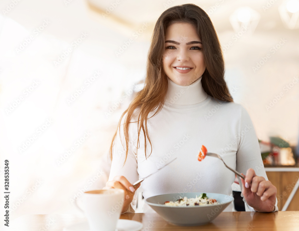 young beautiful smiling woman biting peace of tomatoe while eating salad in cafe during lunch time, food and drink concept young beautiful smiling woman biting peace of tomatoe while eating salad in cafe during lunch time, food and drink concept