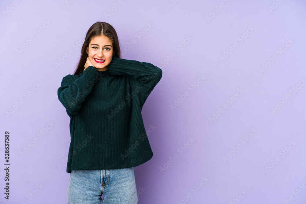 Young caucasian woman isolated on purple background touching back of head, thinking and making a choice. Young caucasian woman isolated on purple background touching back of head, thinking and making a choice.