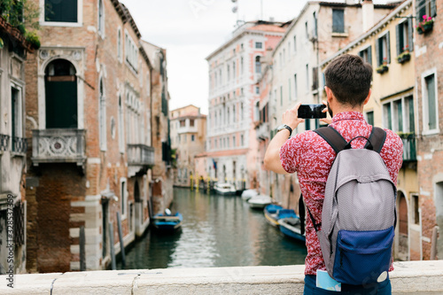 Young traveler taking a photo with his smartphone of a canal in Venice, Italy © marjan4782