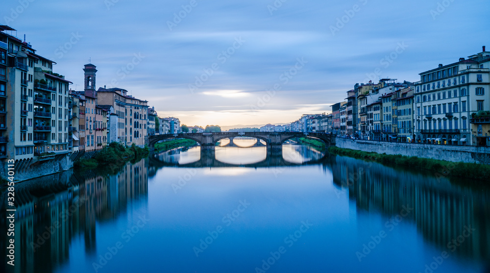 Majestic view of Ponte Vecchio and calm Arno river after thunderstorm in Florence Italy