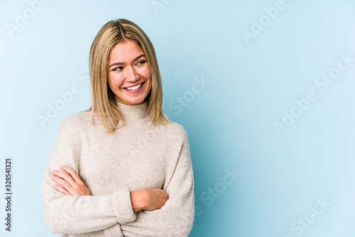 Young blonde caucasian woman isolated smiling confident with crossed arms.