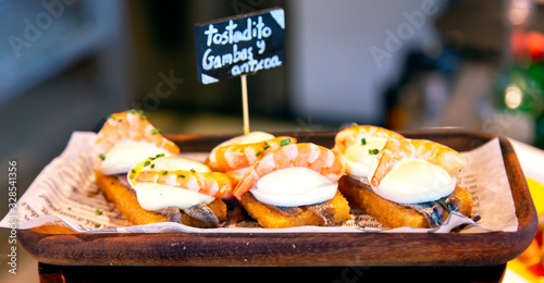 Fotografie, Tablou Appetizing spanish tapas with anchovies and shrimp close-up in the restaurant of