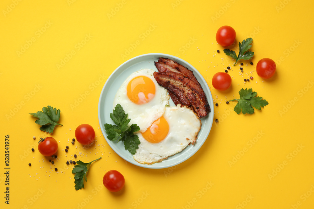 Delicious breakfast or lunch with fried eggs on yellow background, top view Delicious breakfast or lunch with fried eggs on yellow background, top view