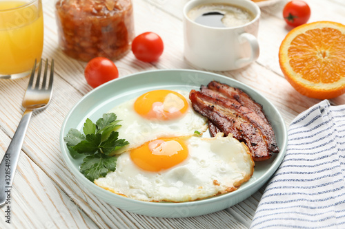 Delicious breakfast or lunch with fried eggs on wooden background, close up