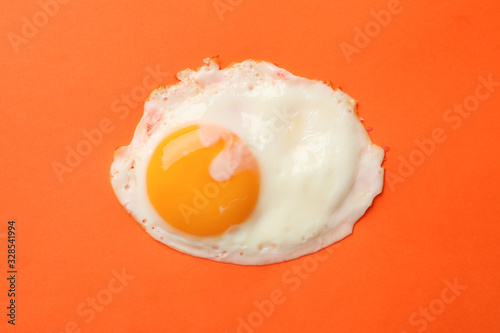 Fried egg on orange background, top view