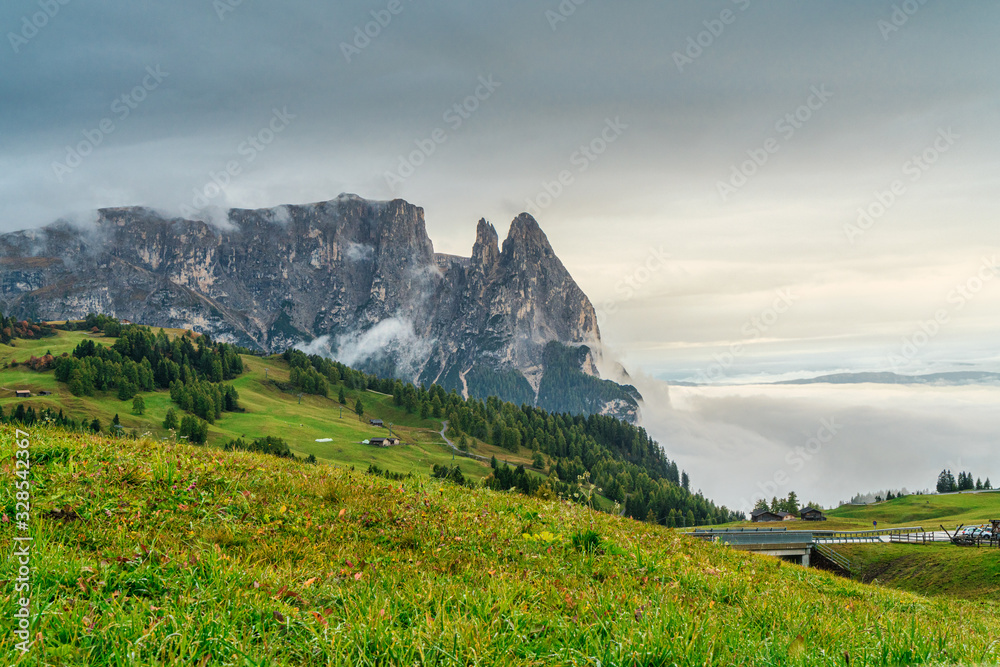 Dolomites mountain landscape cover with low cloud in autumn in Alpe di siusi, Italy