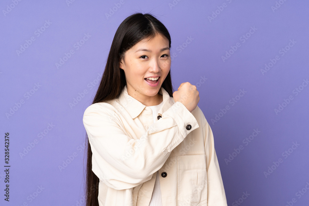 Young asian woman isolated on purple background celebrating a victory Young asian woman isolated on purple background celebrating a victory