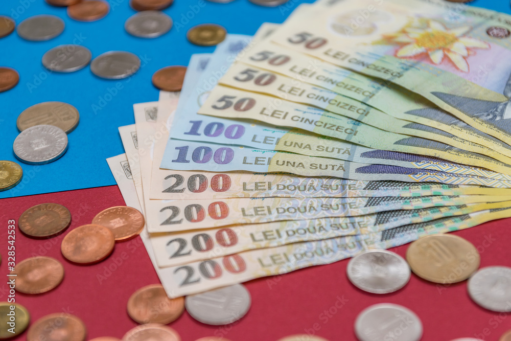 Romanian banknotes and coins on a blue and red background. Coloseup of RON, Romanian Currency. Romanian RON, Lei Banknotes issued by BNR, National Bank of Romania. Romania Finance and economy concept